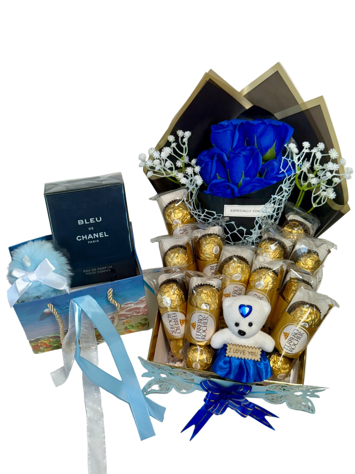 Gourmet gift set with blue roses, chocolates, and a teddy bear on a white background