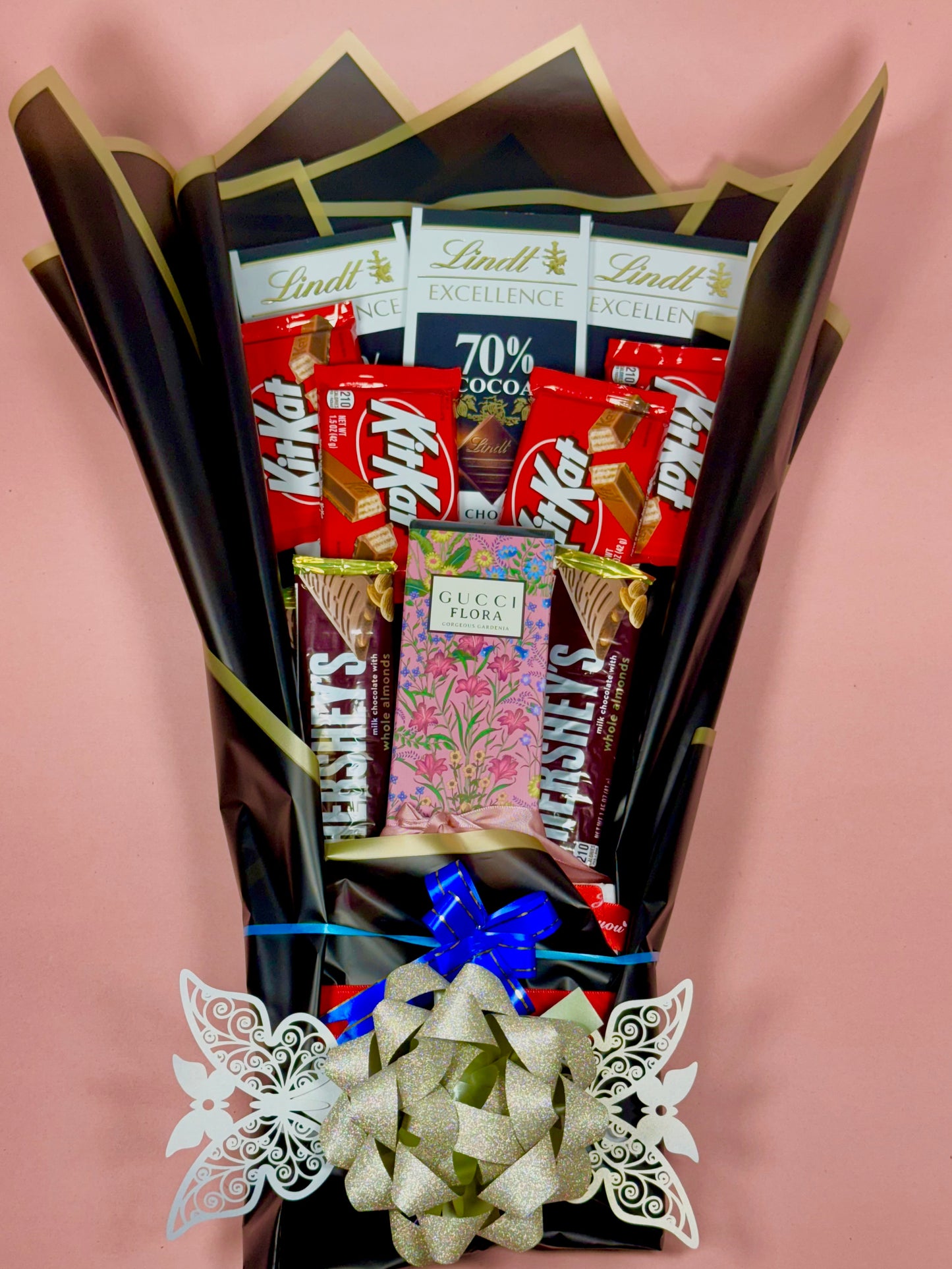 Bouquet of chocolate bars and candies arranged like a bouquet on a pink background