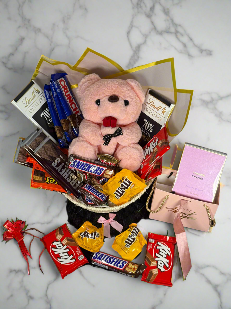 Bouquet of candy bars and a teddy bear on a marble surface