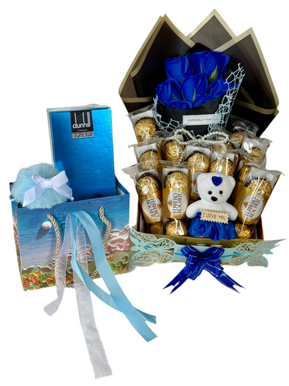 Gift basket with blue roses, chocolates, and a teddy bear on a white background