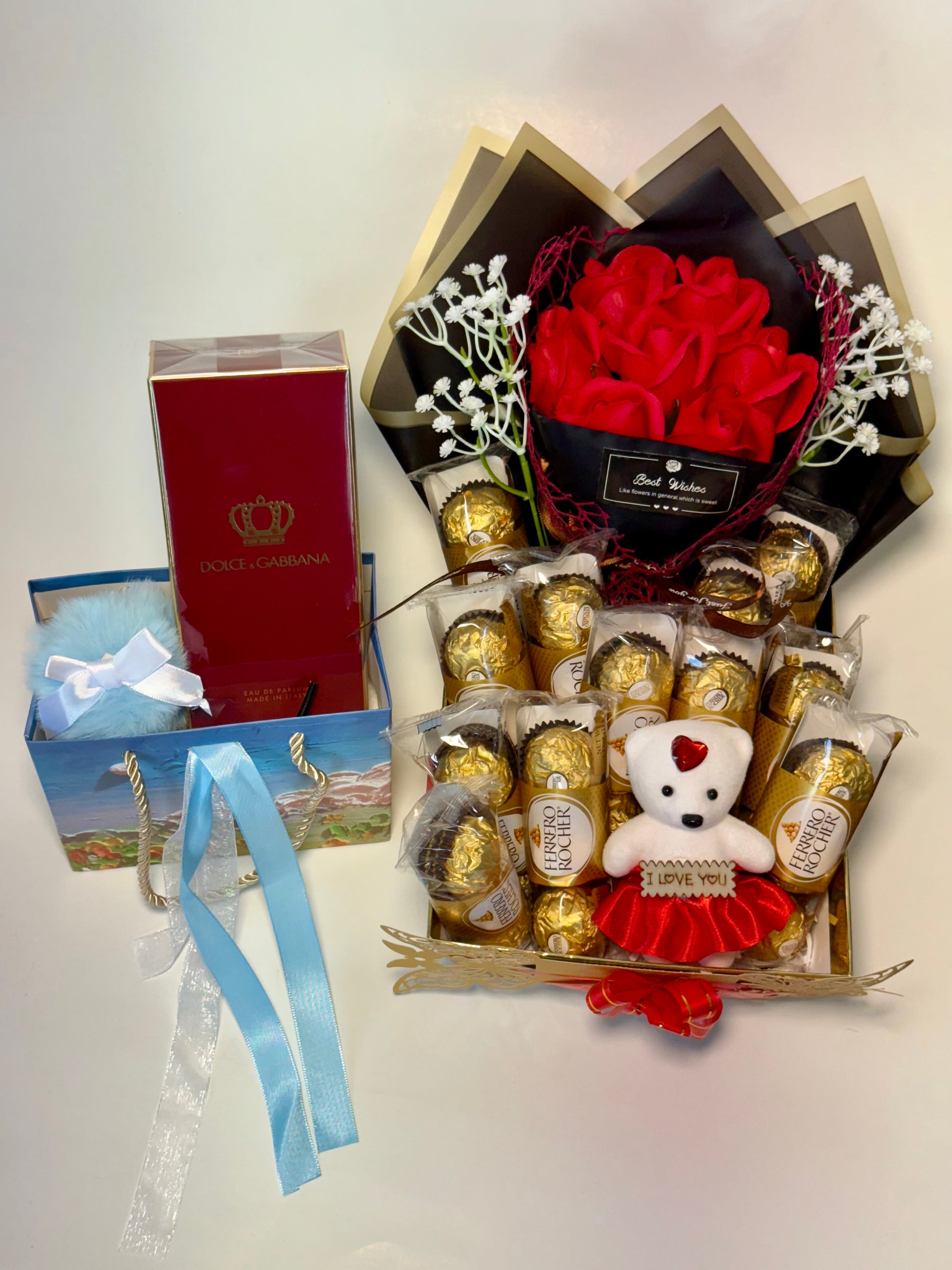 Gift set with chocolates, teddy bear, and flowers on a white background