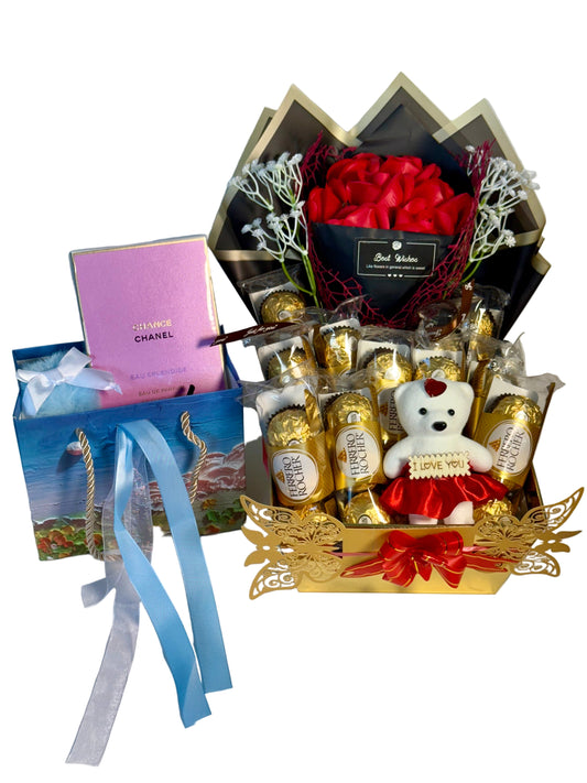 Gift basket with chocolates, a teddy bear, and a Chanel box on a white background