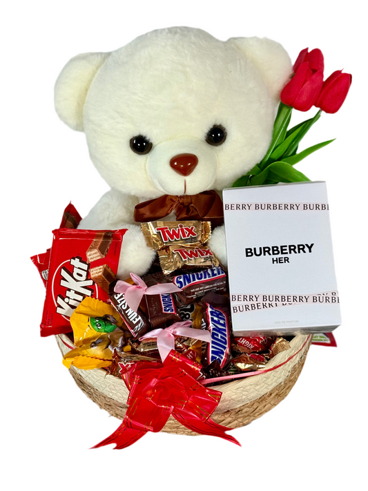 Gift basket with teddy bear, candy, and Burberry perfume on a white background