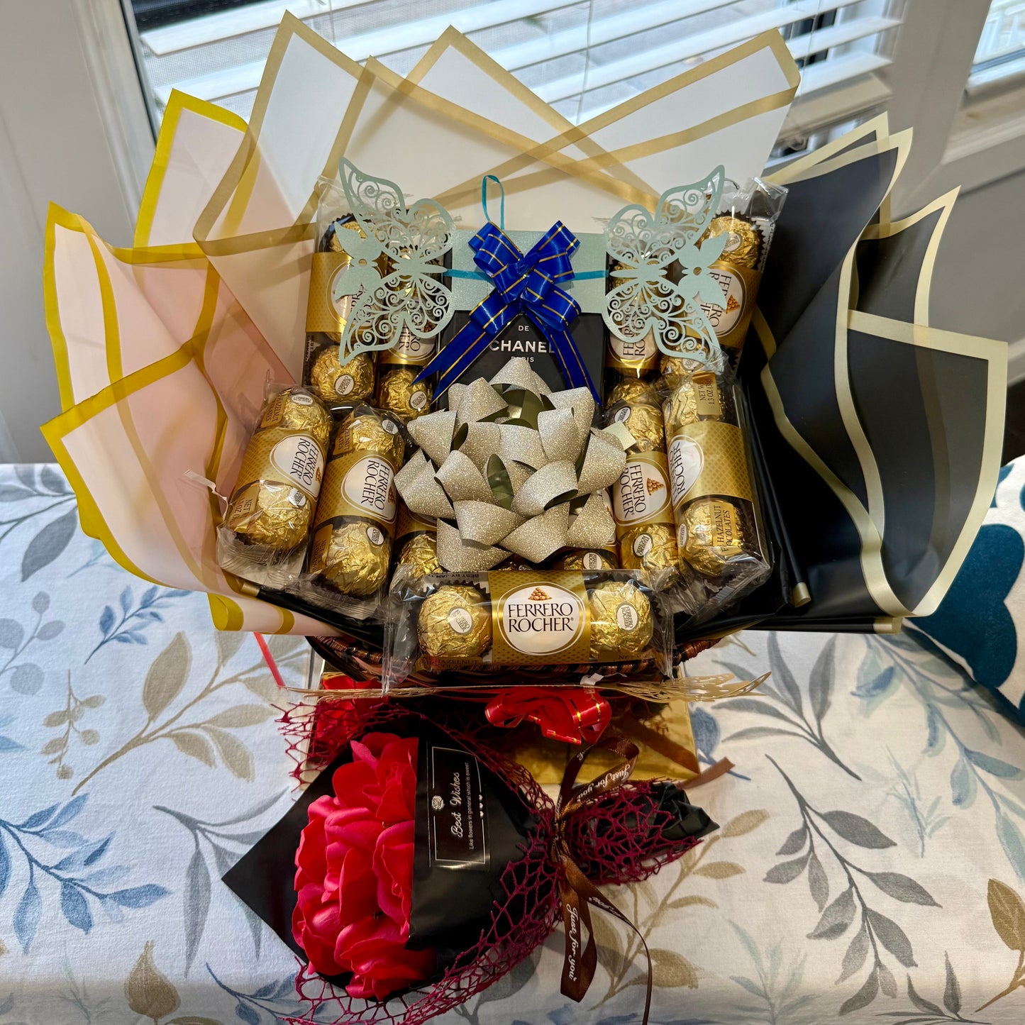 Bouquet of Ferrero Rocher chocolates and flowers on a floral-patterned surface