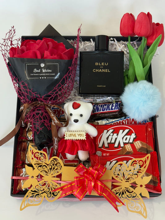 Gourmet gift box with red roses, teddy bear, chocolates, and flowers.