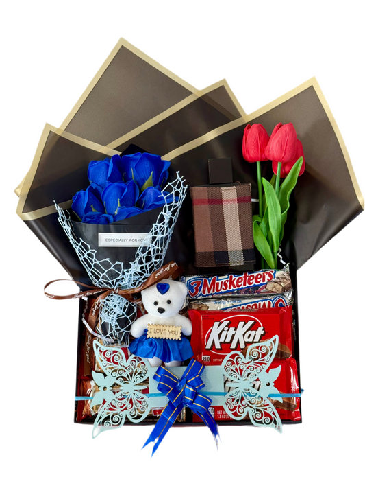 Gift basket with blue roses, red tulips, a teddy bear, and KitKat bars on a white background