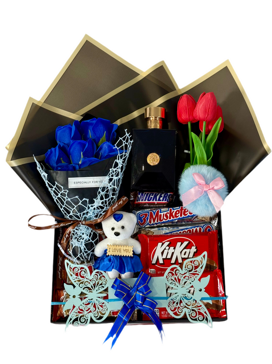 Gift basket with flowers, chocolate, and a teddy bear on a white background